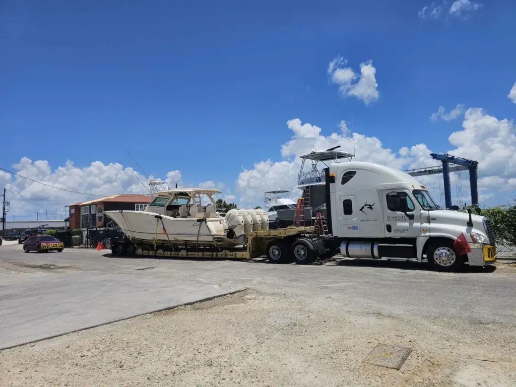 Boat Transport, low boy boat trailer loaded with quad motor boat.