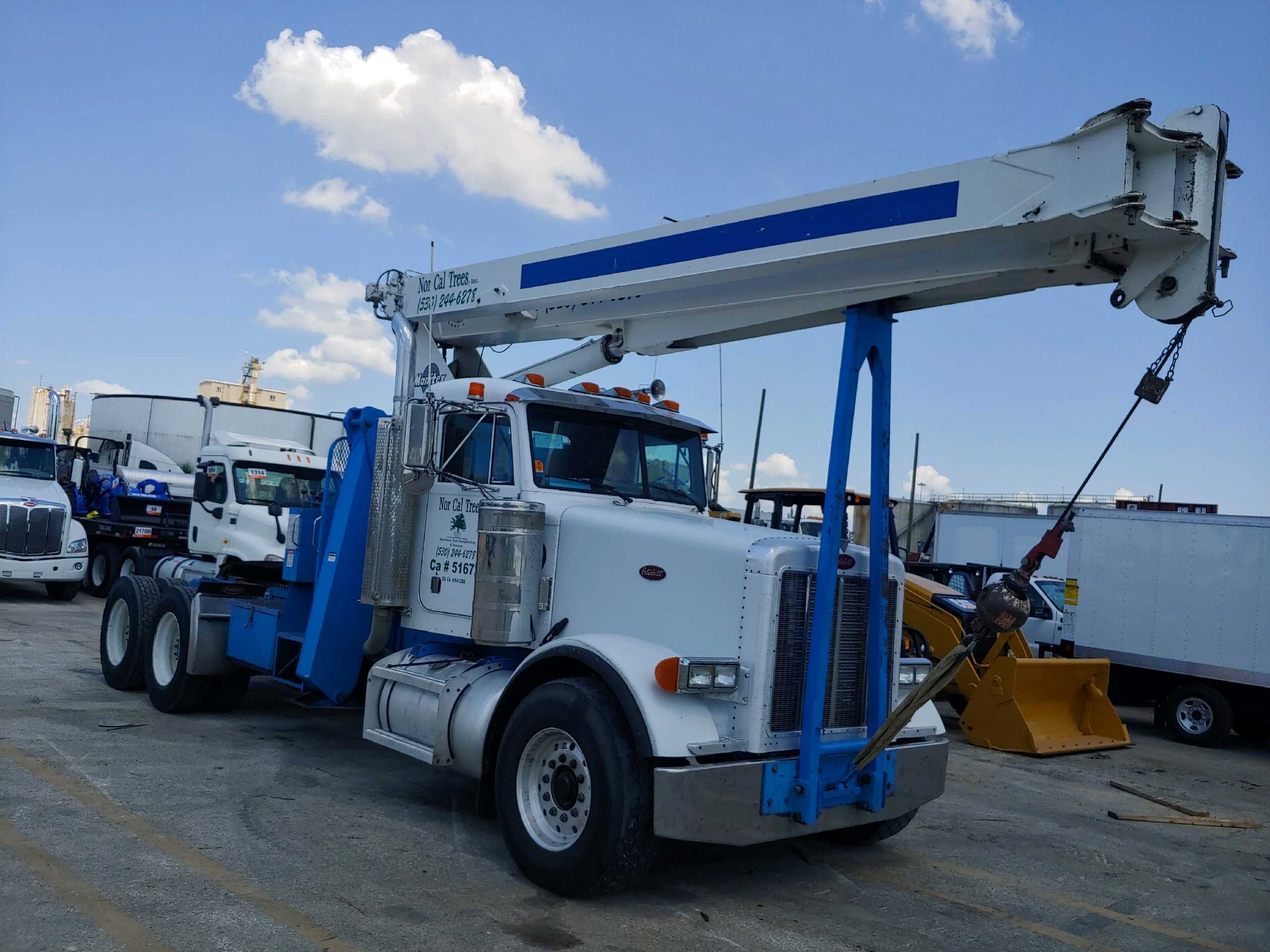 Blue boom truck with aerial device stowed before transport