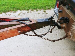 Trailer hitch and safety chains on a combine haul